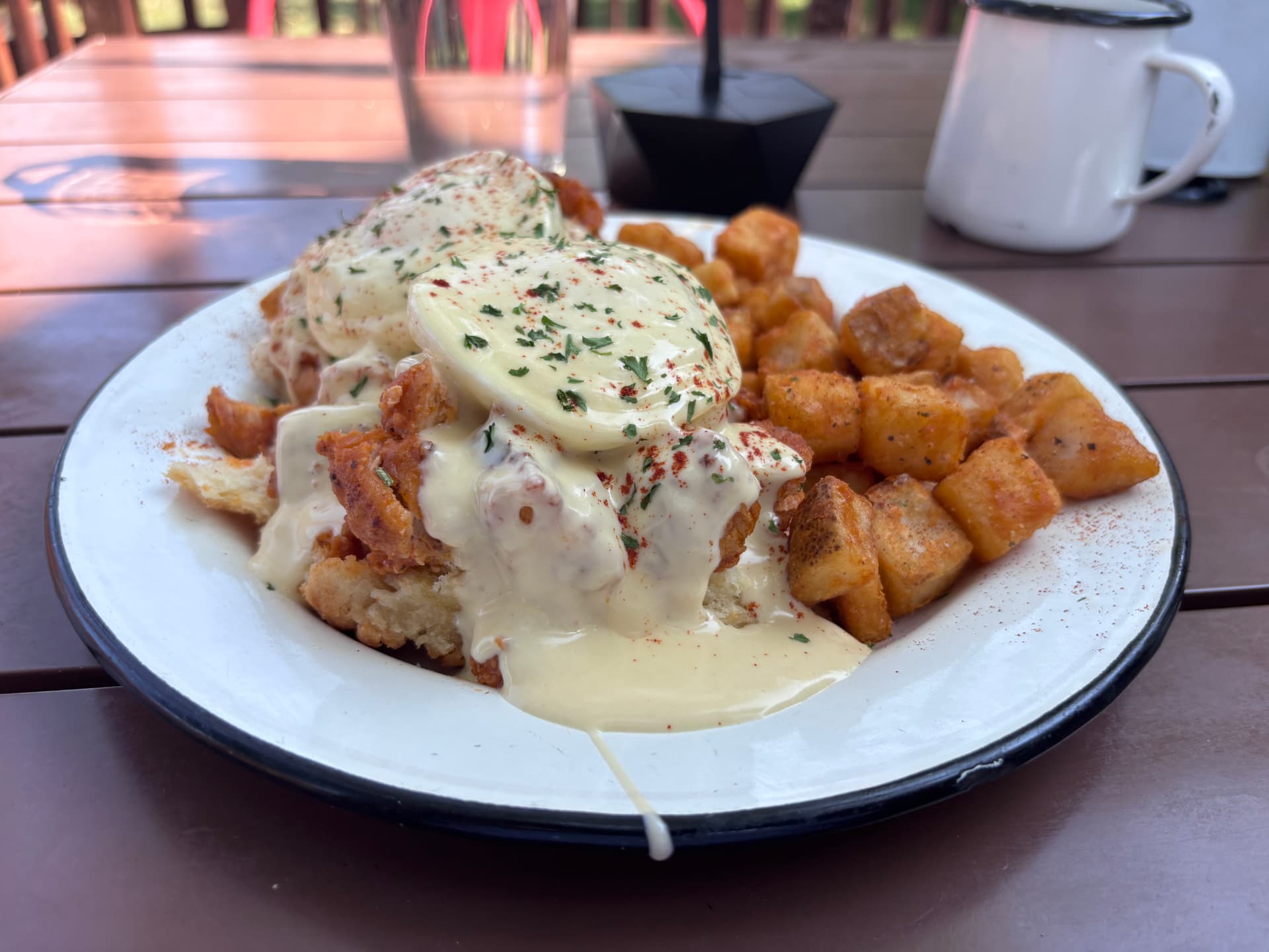 Hot chicken benedict at Hillcrest Little Bakery: fried chicken on a split biscuit topped with poached eggs and sauce, served with breakfast potatoes